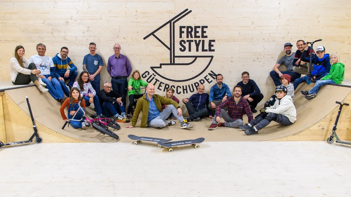 Eine Gruppe sitzt in einer Halle in einer Rampe.